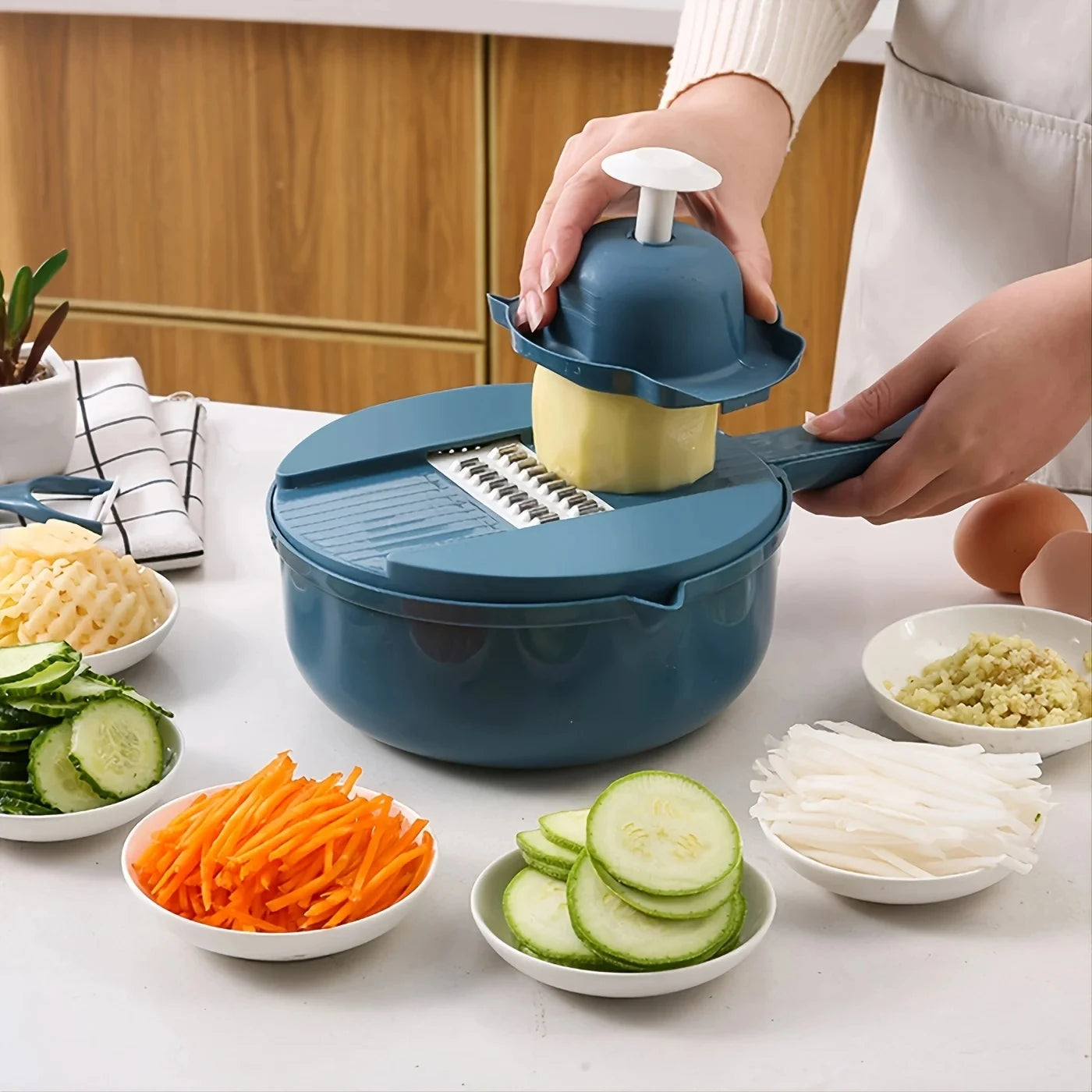 Person using a blue mandoline slicer to slice vegetables on a kitchen counter.