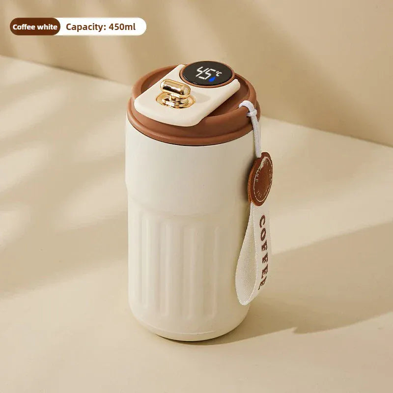 White ceramic mug with brown lid and handle on a beige background