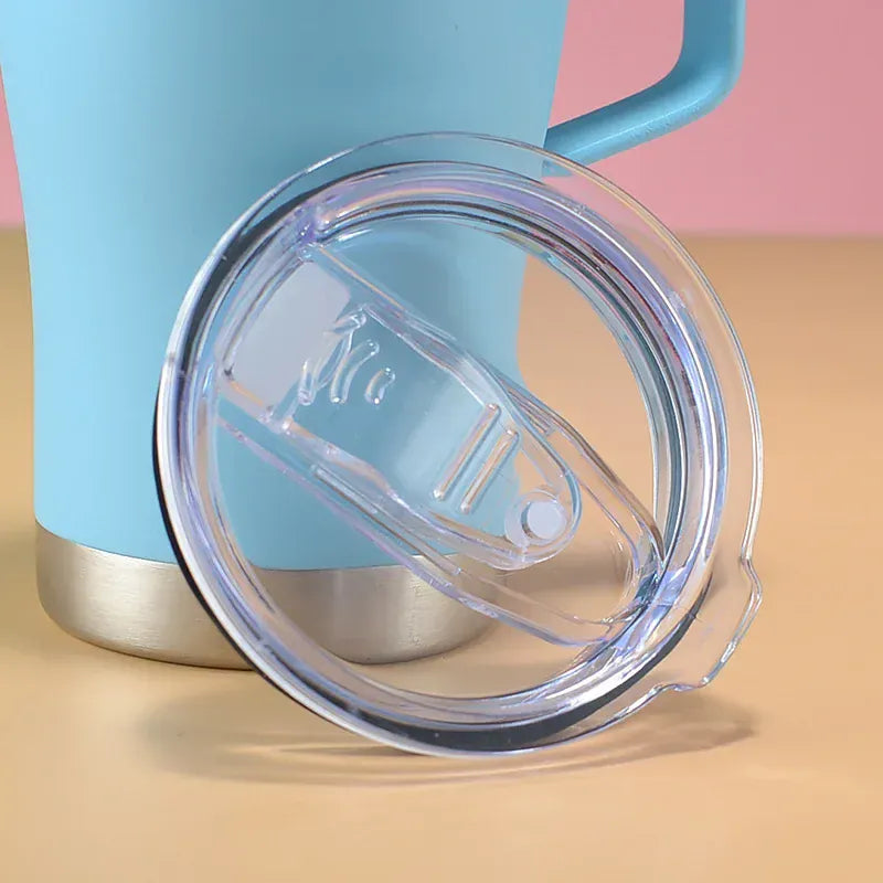 Blue tumbler with a clear lid on a beige surface