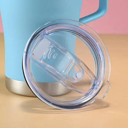 Blue tumbler with a clear lid on a beige surface