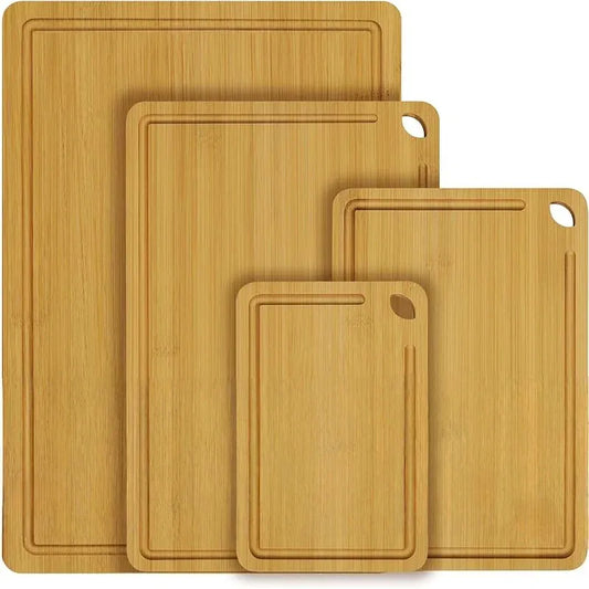 Set of four bamboo cutting boards of different sizes on a white background