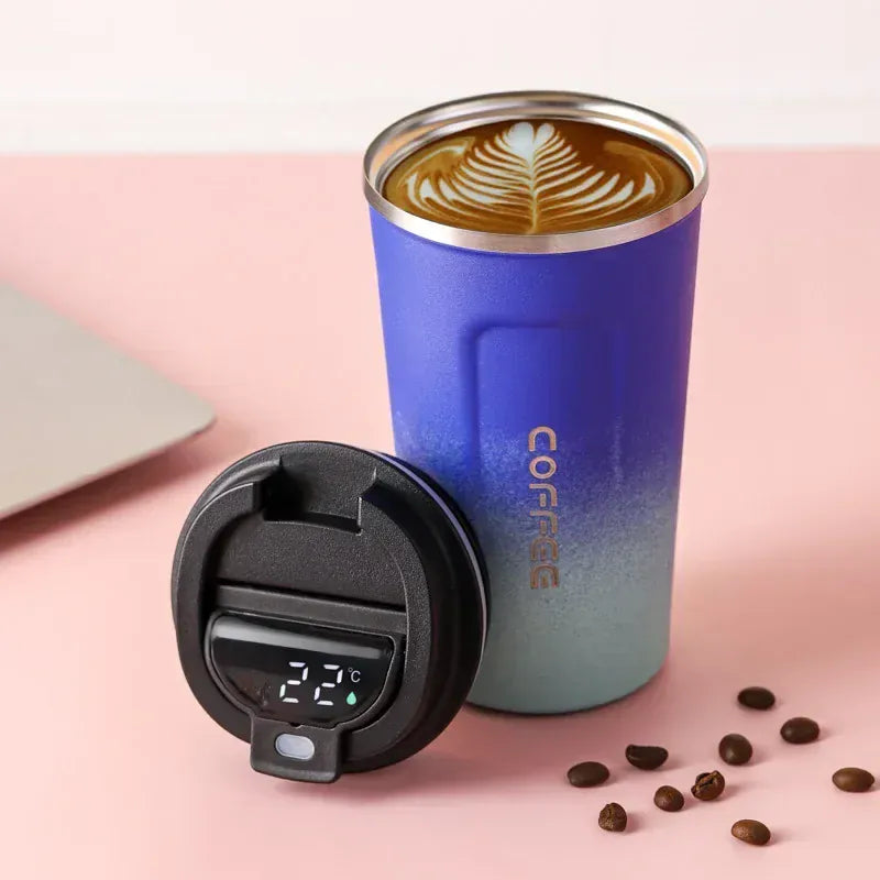 Blue insulated coffee tumbler with a digital temperature display on a pink background