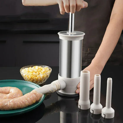 Person using a sausage stuffer with various attachments on a dark surface.