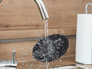 Water flowing from a faucet into a sink with a wooden background