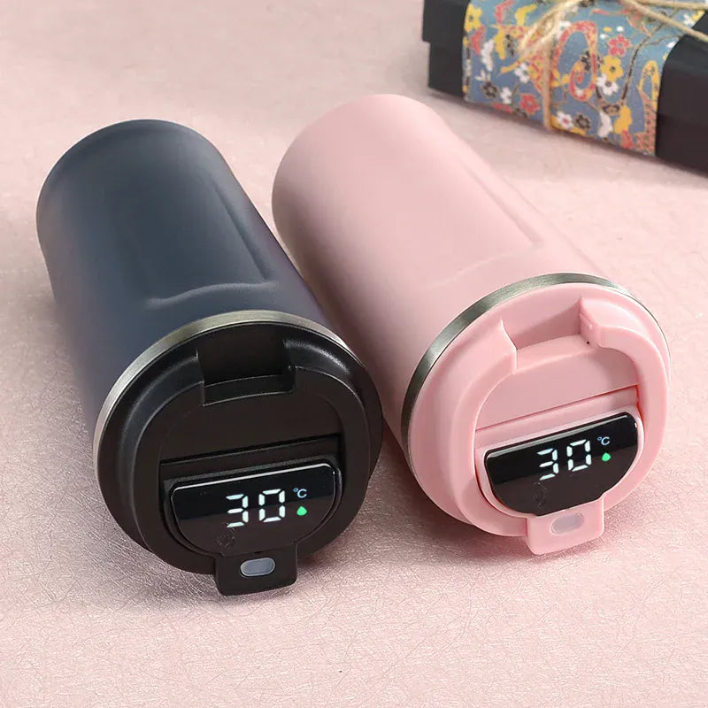 Two thermos bottles, one black and one pink, with digital temperature displays on a light pink background.
