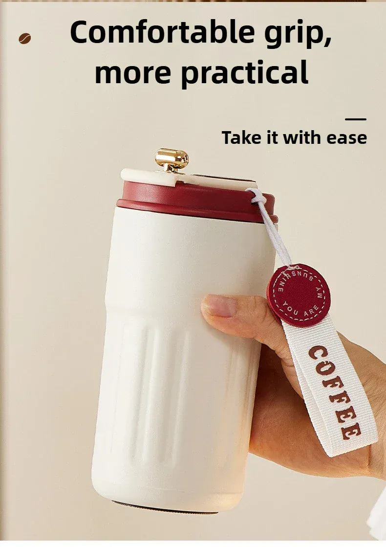 White coffee cup with red lid held by a hand, text 'Comfortable grip, more practical. Take it with ease.'
