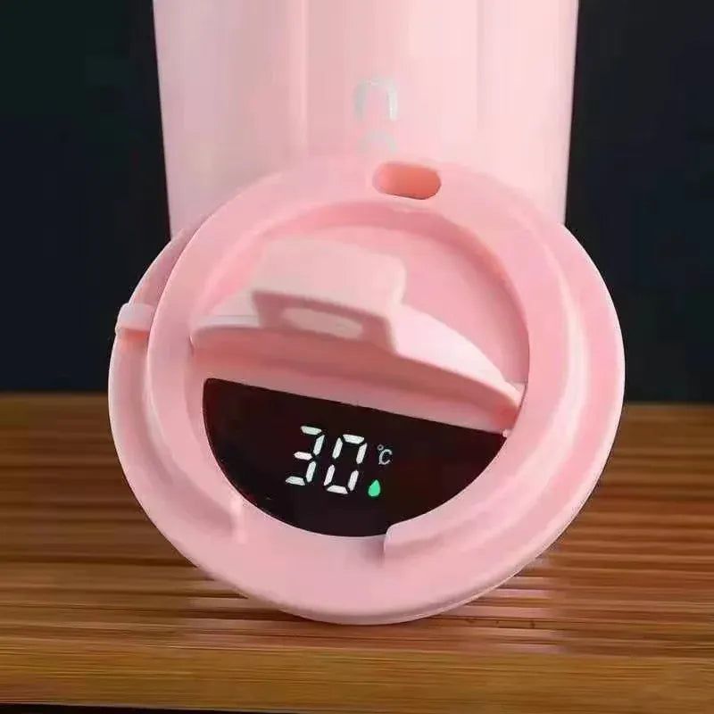 Pink thermos with digital temperature display on a wooden surface