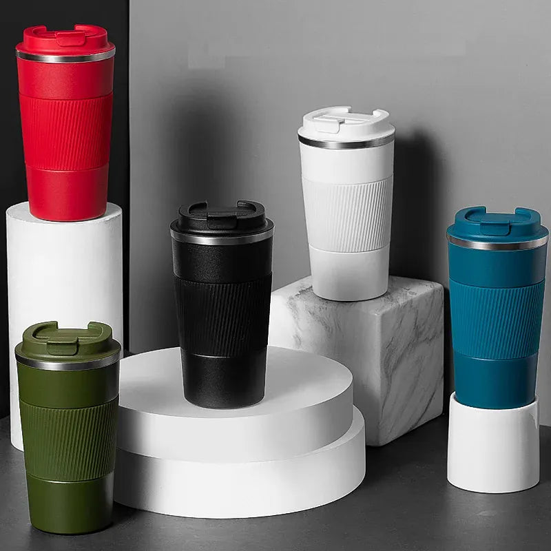 Set of colorful travel mugs on a gray background