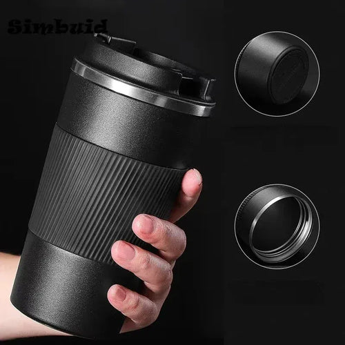Black travel mug held in a hand with close-up details on a black background