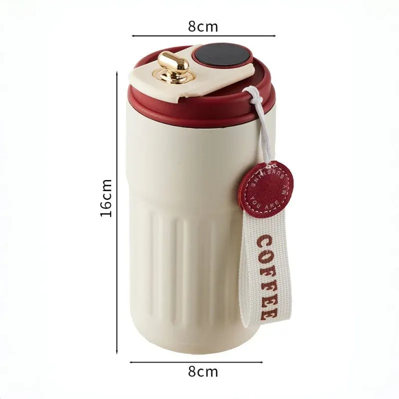 Beige travel mug with red lid and 'COFFEE' strap, shown with dimensions on a white background.