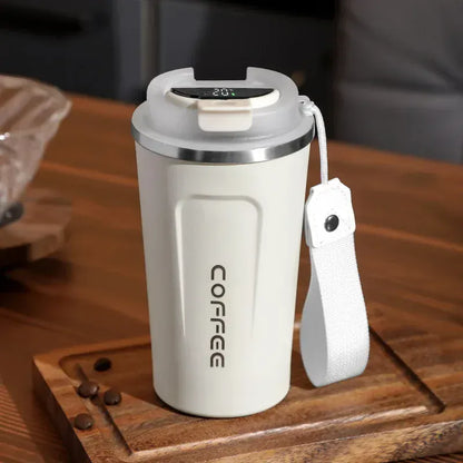 White electric coffee maker on a wooden surface with a strap attached