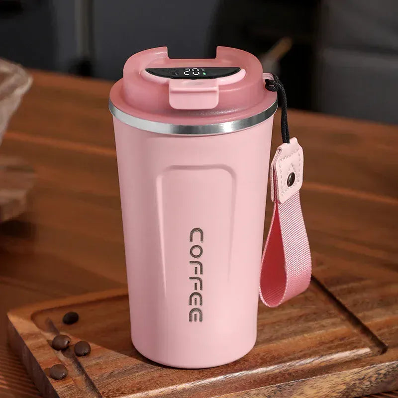 Pink thermos mug with digital display on a wooden surface