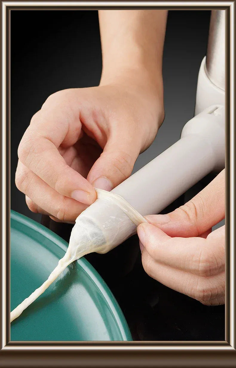 Person using a white tool to apply a substance onto a green surface.
