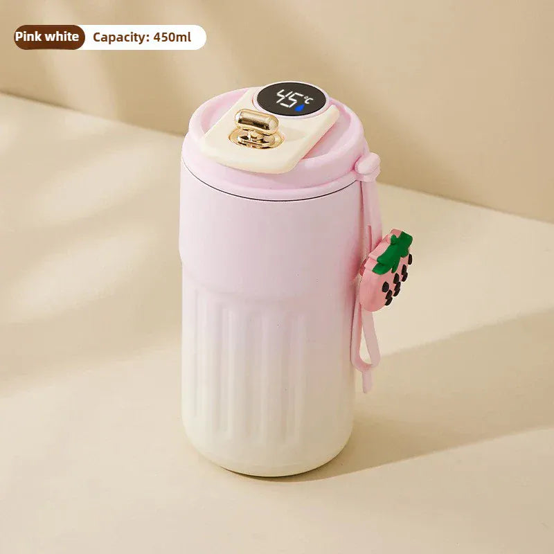 Gradient pink and white tumbler with a straw on a beige background