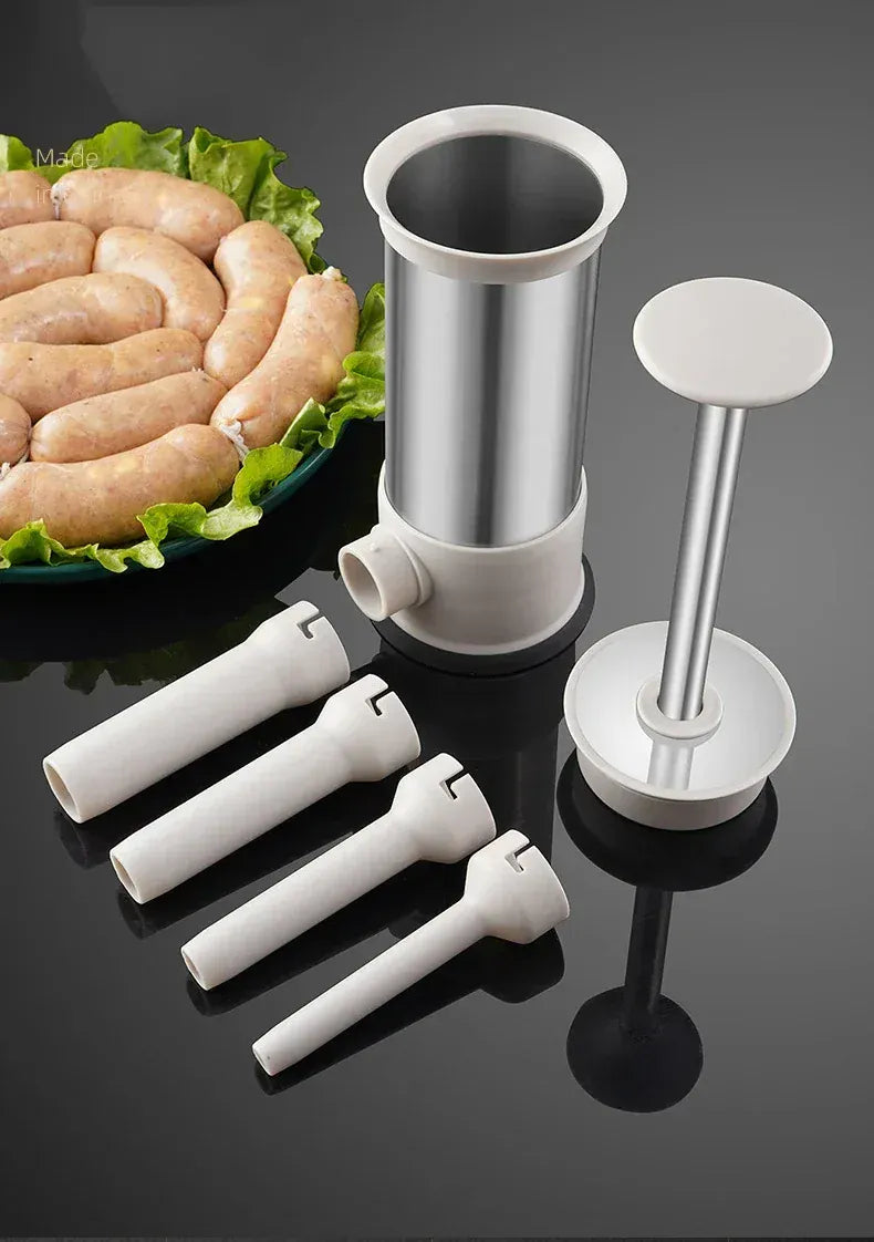 Sausage stuffer with four white sleeves on a dark surface, with sausages and lettuce in the background.