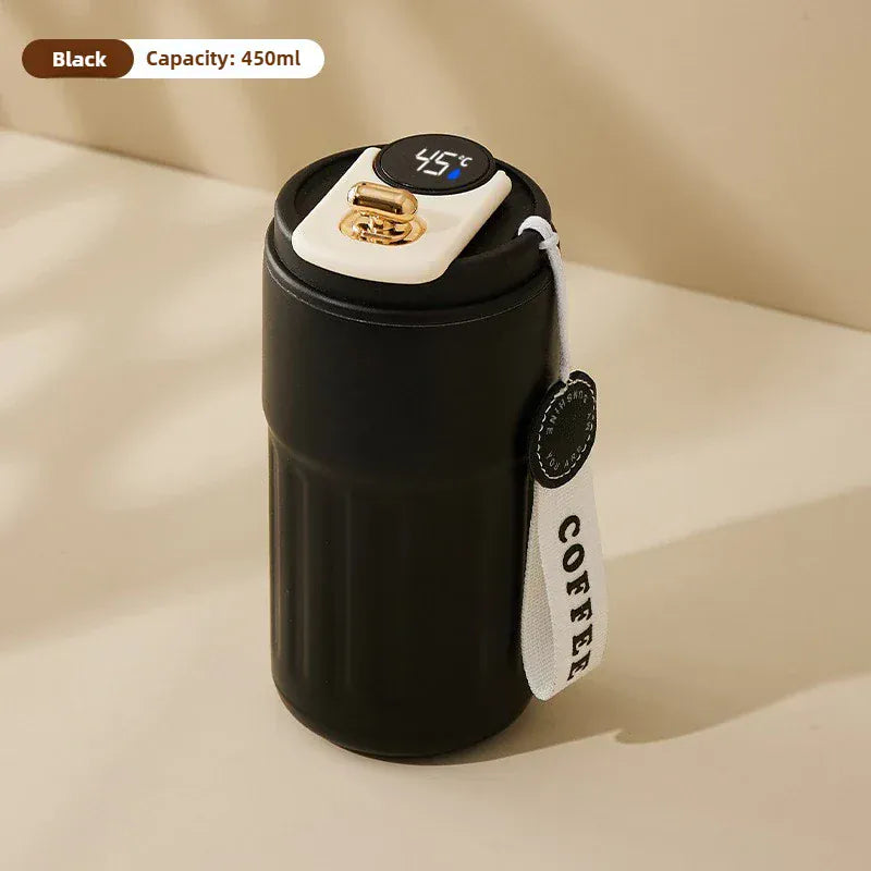 Black insulated coffee cup with digital temperature display on a beige background
